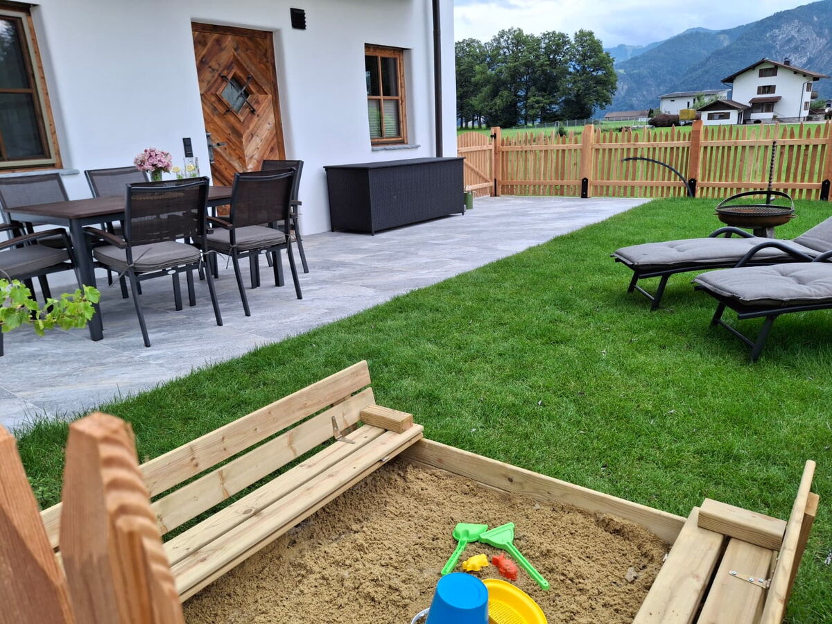 Garten am Riedhof-Zuahaus mit Sitzgruppe, Rasen und Sandkasten, familienfreundlicher Bauernhofurlaub in Breitenbach in Tirol
