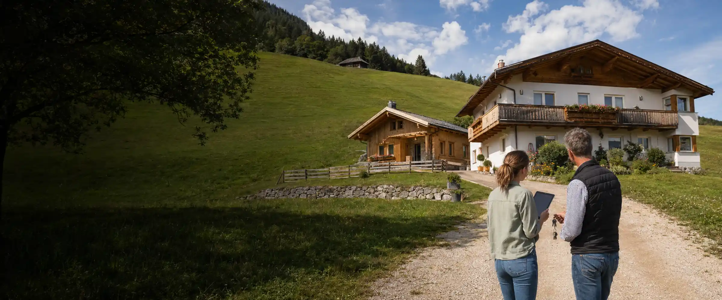 Two people with documents in front of a house and holiday house on the slope